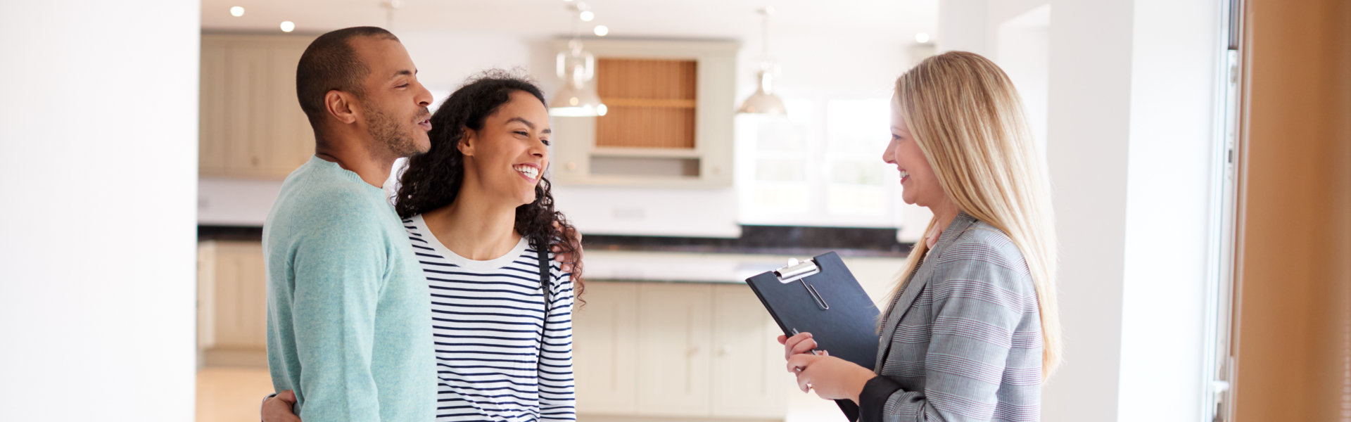 couple and female realtor smiling at each other